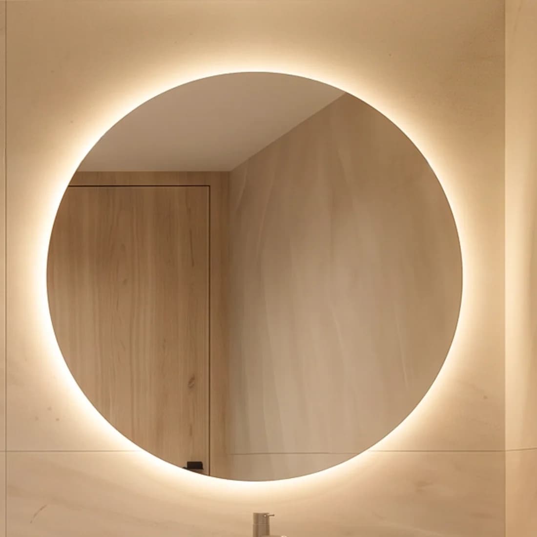 Round backlit mirror above the washbasin wall